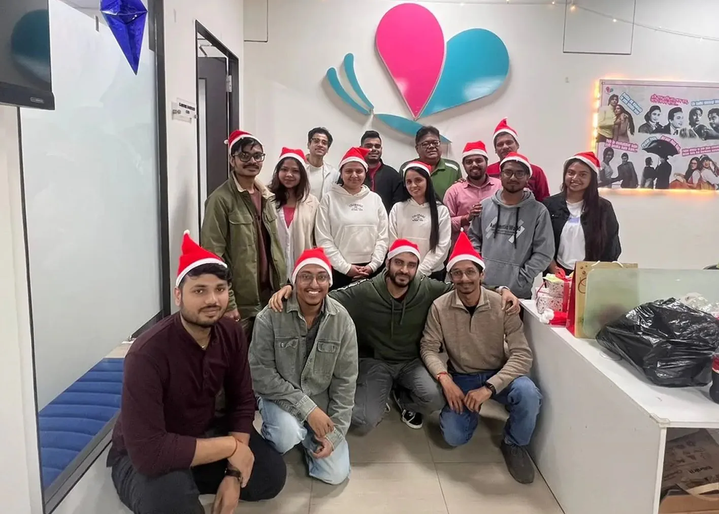 The team in Santa hats in front of the flutrr logo